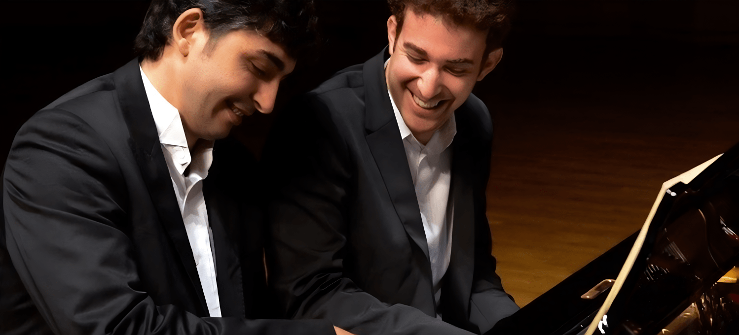 two gentleman playing the piano on stage