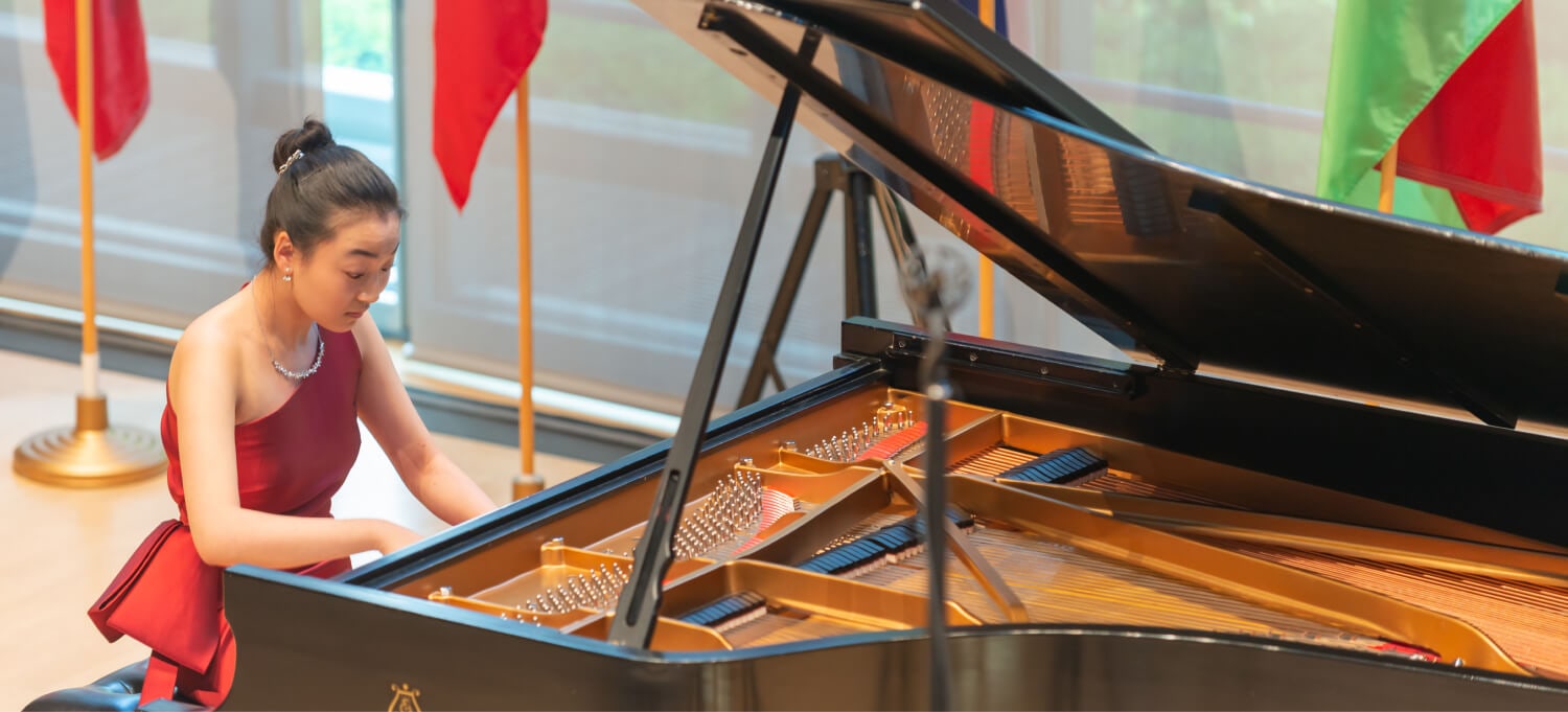 pianist performing at a piano in red dress